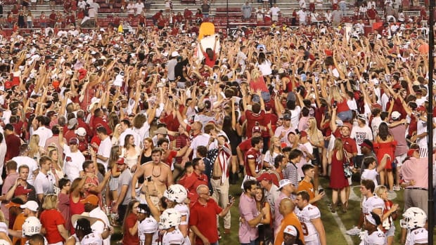 Razorback fans rush Razorback Stadium after a win over Texas in 2021.